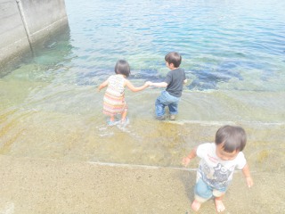 波打ち際で遊ぶ子どもたち。