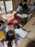 （う）と遊ぶ女子、ゲームに夢中な男子。